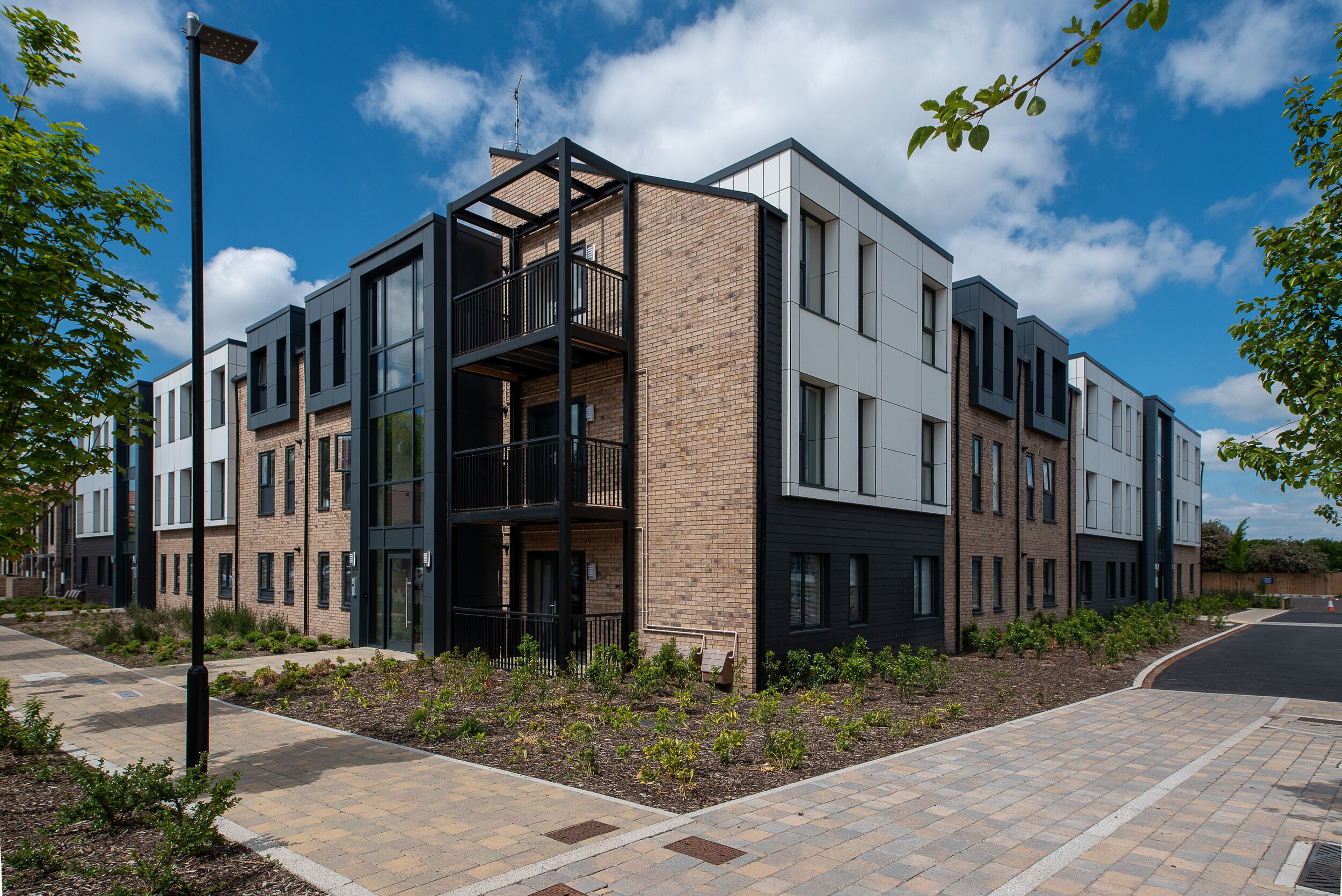 Three storey block of apartments with contrasting white and black cladding